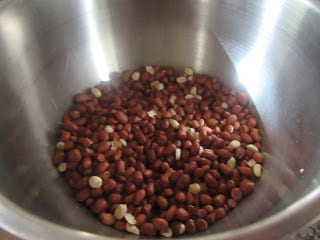 Raw groundnuts (peanuts) in a stainless steel bowl